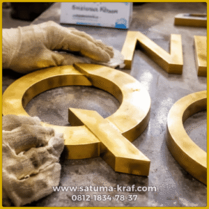 hasil finishing logo kuningan timbul warna mengkilap
