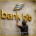 pemasangan logo kuningan timbul pada dinding kantor