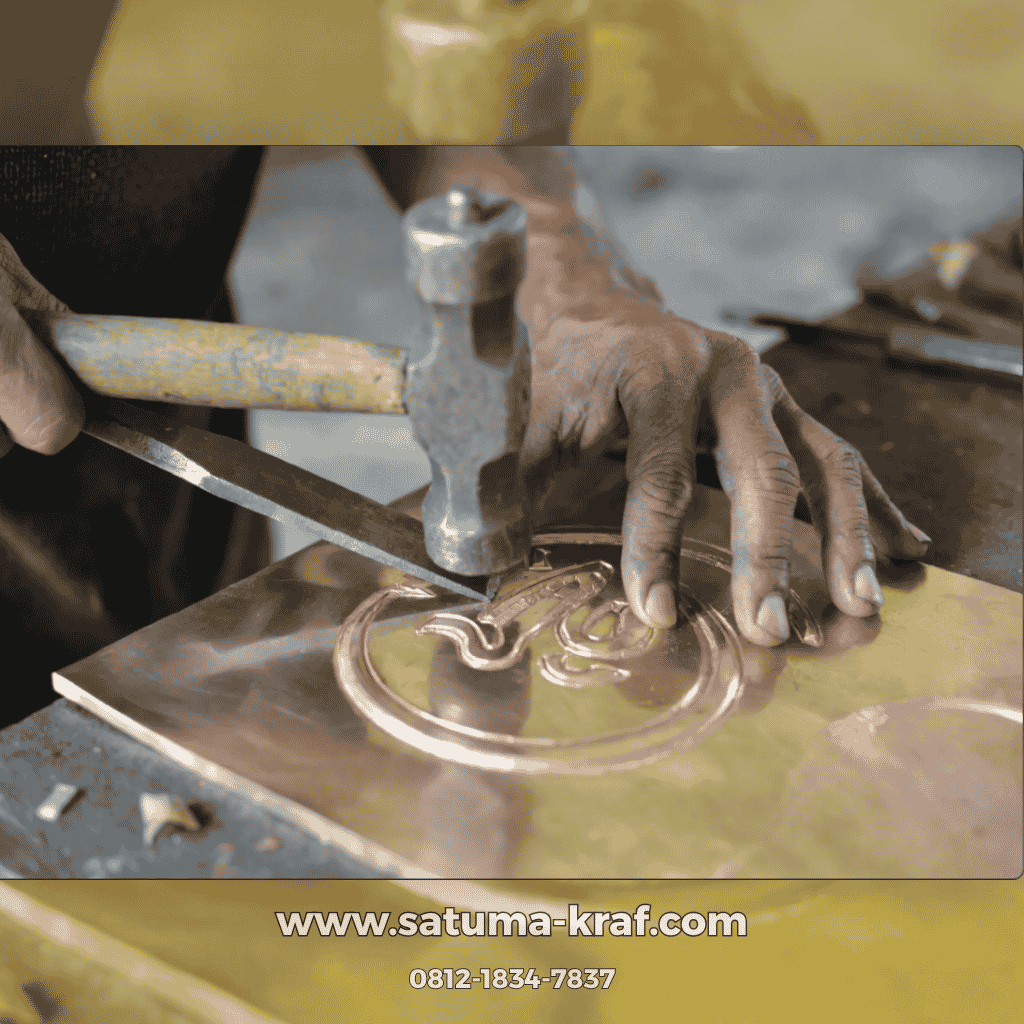 Tangan pengrajin memahat ornamen kaligrafi tembaga